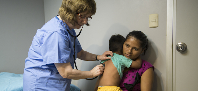 Doctor examining child with mother